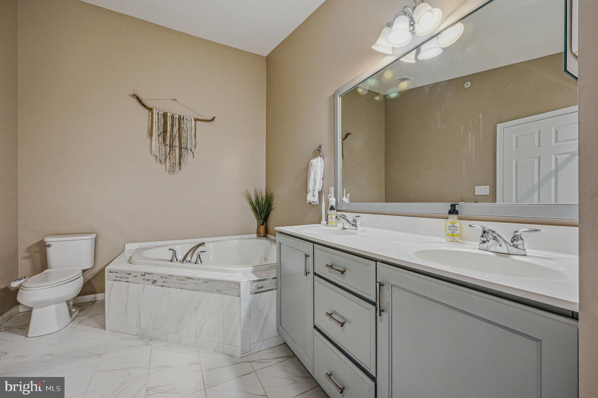 208 Jackdaw Alley, Unit 208 Springfield, PA 19064 - Photo 32 of 43 a bathroom with a toilet sink and mirror