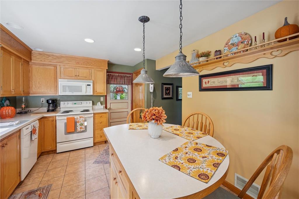 4941 Bulltown Road Murrysville, PA 15668 - Photo 12 of 39 a kitchen with stainless steel appliances granite countertop a sink a stove and chairs