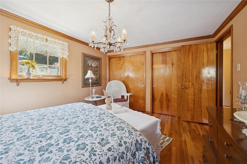 4941 Bulltown Road Murrysville, PA 15668 - Photo 27 of 39 a bedroom with a large bed and a chandelier next to a window