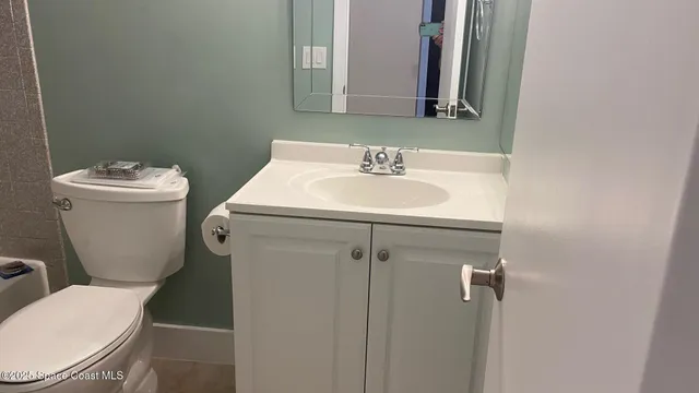 a bathroom with a toilet sink and mirror