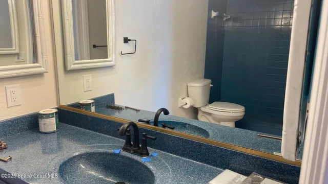 a bathroom with a toilet a sink and mirror