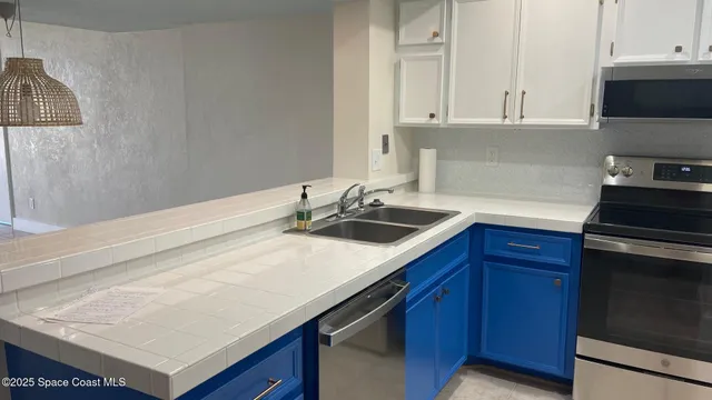 a kitchen with a sink dishwasher and cabinets