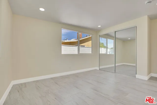 an empty room with windows and closet