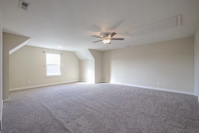 a view of an empty room with a chandelier fan