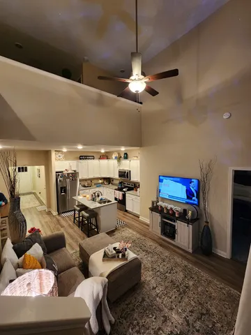 a living room with furniture a rug and kitchen view