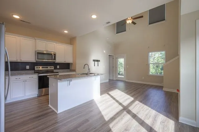 a kitchen with granite countertop a stove and a wooden floors