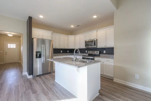 a kitchen with stainless steel appliances granite countertop a sink stove and refrigerator
