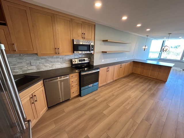 720 West Gordon Terrace, Unit 6D Chicago, IL 60613 - Photo 4 of 28 a kitchen with stainless steel appliances granite countertop a stove a sink and a microwave