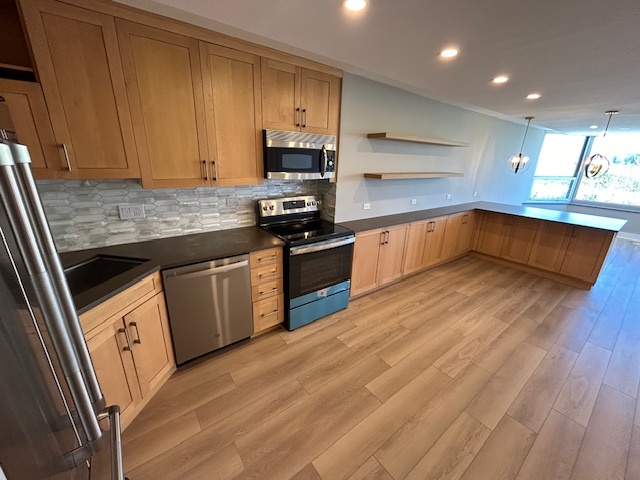 720 West Gordon Terrace, Unit 6D Chicago, IL 60613 - Photo 5 of 28 a kitchen with stainless steel appliances granite countertop a sink a stove top oven a counter space and cabinets