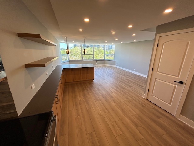 720 West Gordon Terrace, Unit 6D Chicago, IL 60613 - Photo 9 of 28 a view of an empty room with wooden floor and stairs