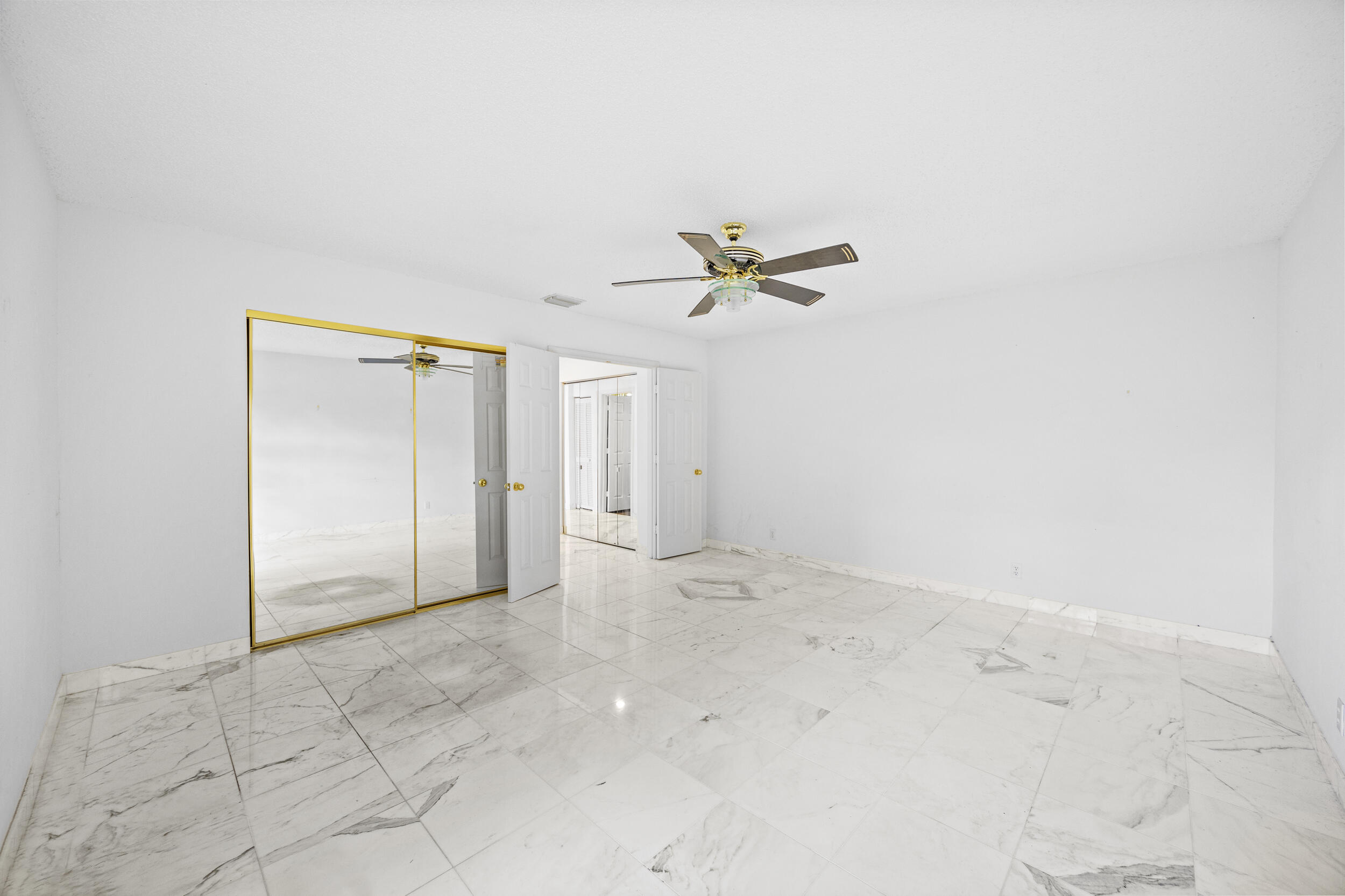 10747 Stonebridge Boulevard Boca Raton, FL 33498 - Photo 27 of 75 an empty room with a empty space and a ceiling fan view