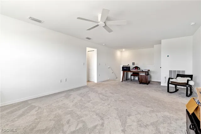 a view of a livingroom with furniture and a ceiling fan