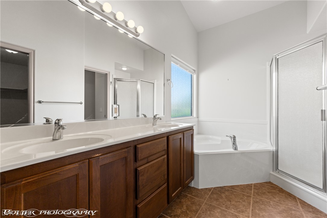 874 Glendale Road Mesquite, NV 89027 - Photo 39 of 71 A primary bathroom featuring dual vanities, a separate shower, and a soaking tub.