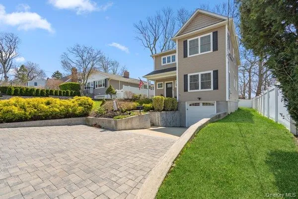 a front view of a house with a yard and potted plants