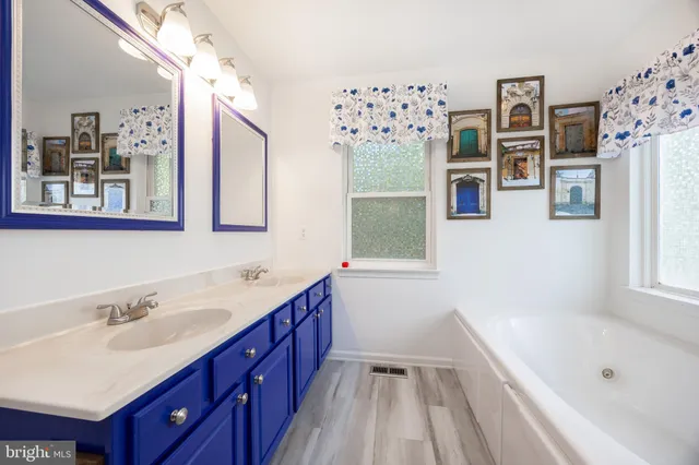 a bathroom with a tub sink and mirror