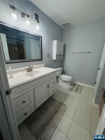 a bathroom with a double vanity sink mirror and toilet
