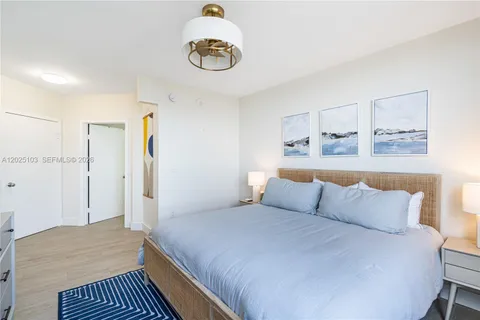 a bedroom with a bed and painting on the wall