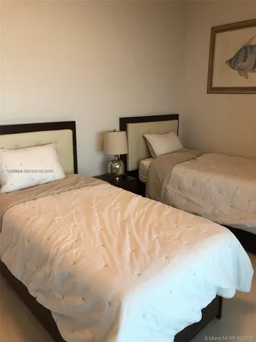 a large bed sitting in a bedroom with a lamp