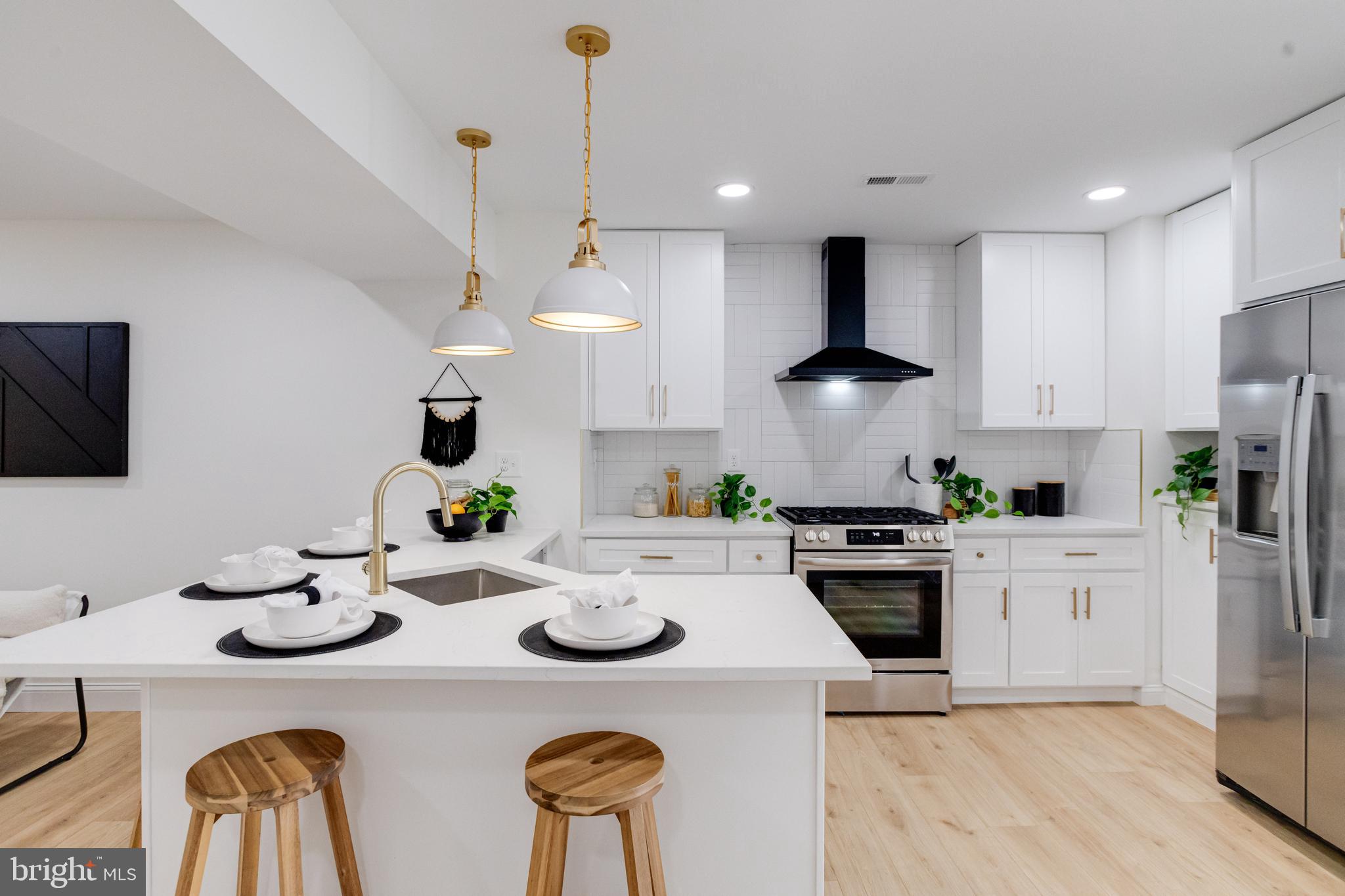 1729 Winans Avenue Halethorpe, MD 21227 - Photo 4 of 40 a kitchen with stainless steel appliances a stove a sink a stove a refrigerator cabinets a dining table and chairs