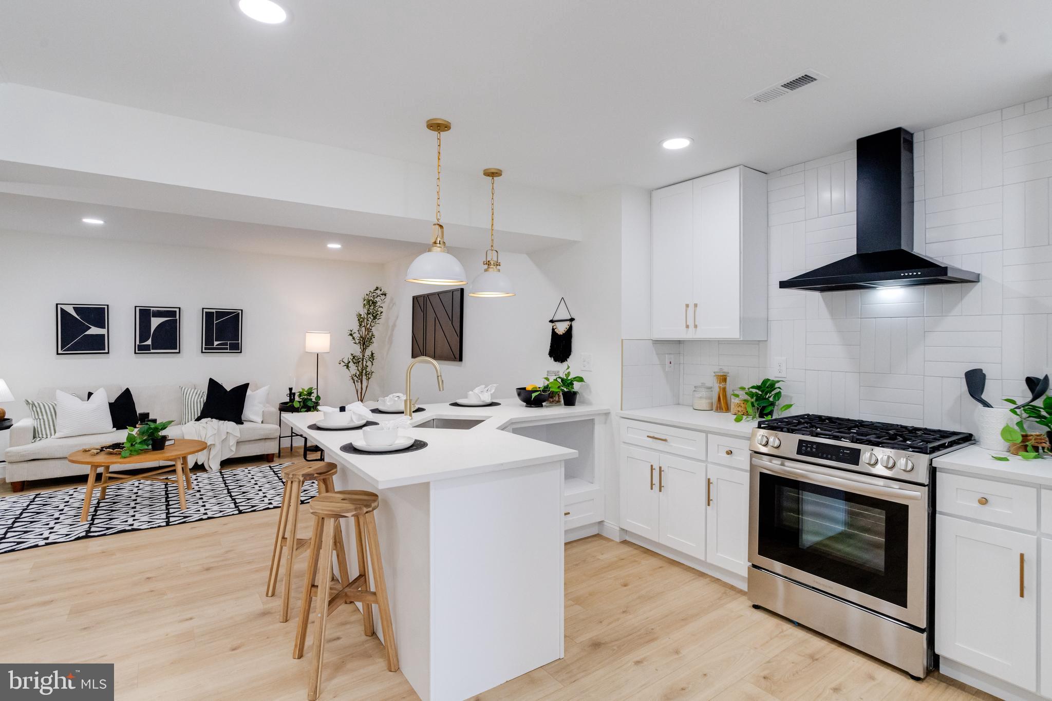 1729 Winans Avenue Halethorpe, MD 21227 - Photo 9 of 40 a kitchen with stainless steel appliances kitchen island granite countertop a stove a sink a refrigerator and white cabinets with wooden floor
