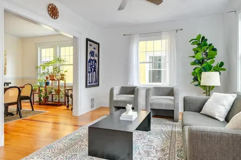 a dining room with wooden floor and large windows