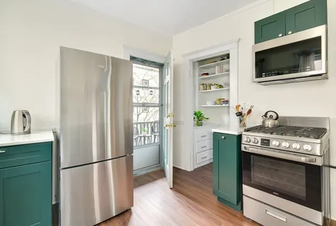 a kitchen with a refrigerator sink and cabinets