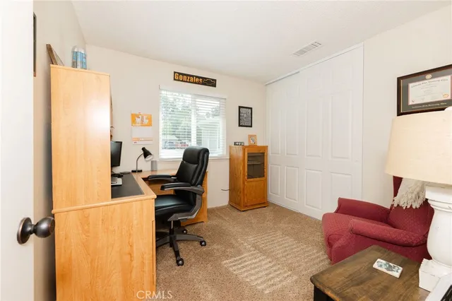 a view of a workspace with furniture and a window
