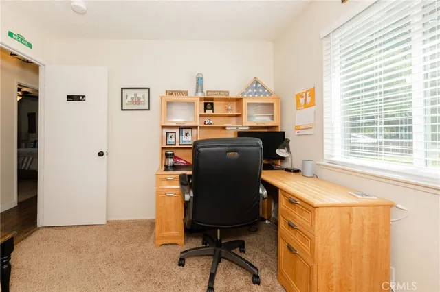 a view of a workspace with furniture and a window