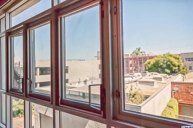 a view of a glass door with a balcony from a window