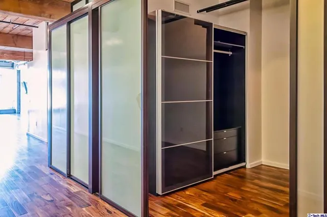 a room with wooden floor and a bathroom