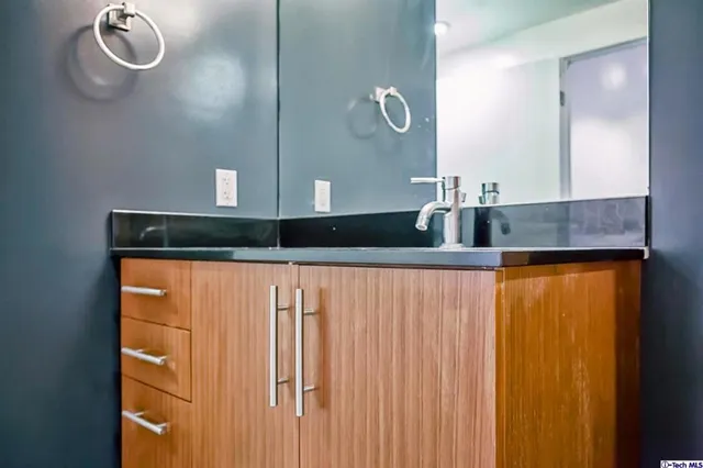 a bathroom with a granite countertop sink and a mirror