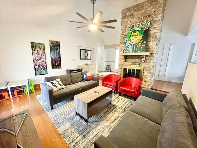 a living room with furniture a fireplace and a chandelier