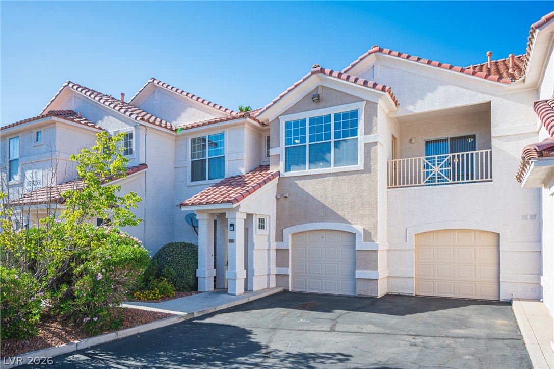 Mediterranean-inspired townhome with a private balcony and attached garage, offering comfortable living.