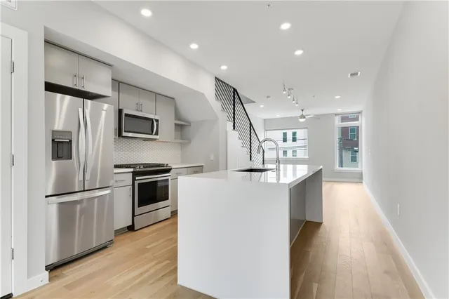 a kitchen with stainless steel appliances a refrigerator and a stove top oven
