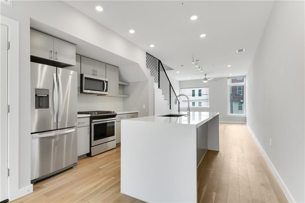 a kitchen with stainless steel appliances a refrigerator and a stove top oven