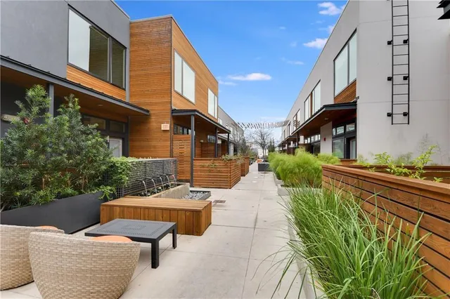 a view of a patio with couches table and chairs and potted plants