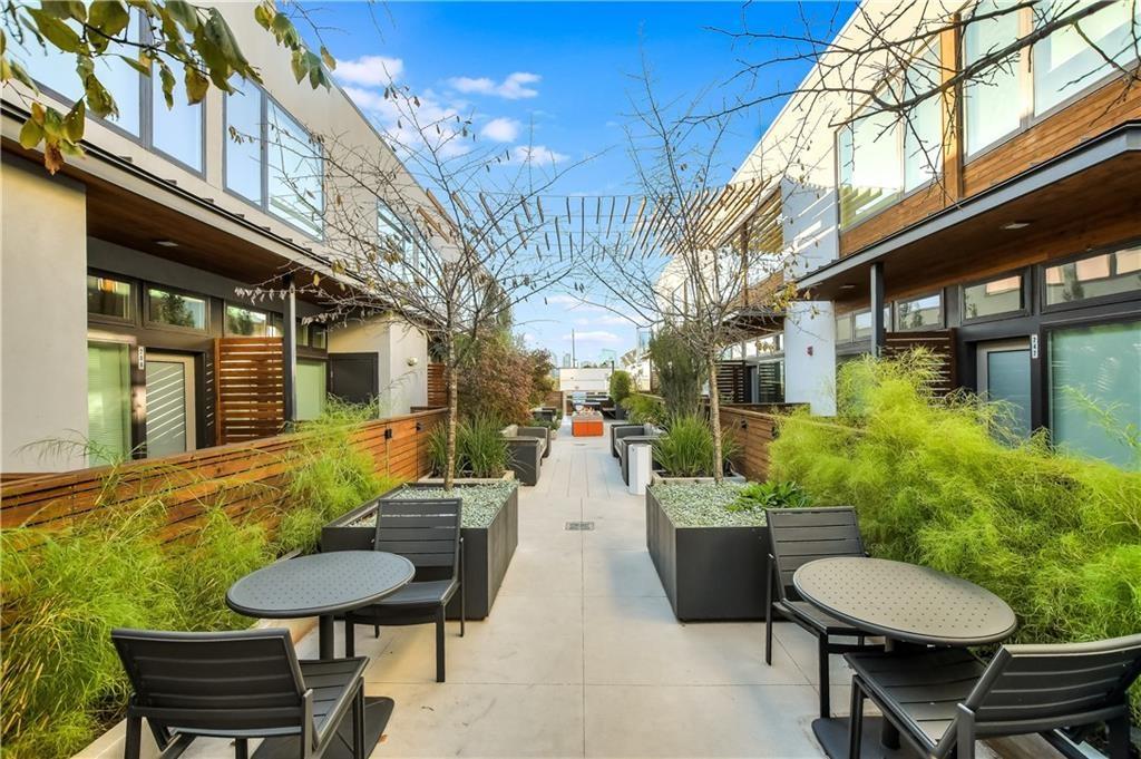 2002 East 7th Street, Unit 212 Austin, TX 78702 - Photo 20 of 23 a view of a patio with table and chairs with wooden fence and plants