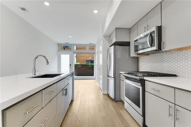 a kitchen with stainless steel appliances granite countertop a sink stove and refrigerator