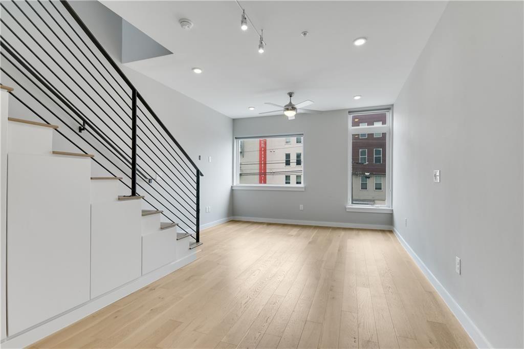 2002 East 7th Street, Unit 212 Austin, TX 78702 - Photo 6 of 23 an entryway in a hall with wooden floor and stairs