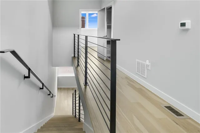 a view of staircase with railing and white walls
