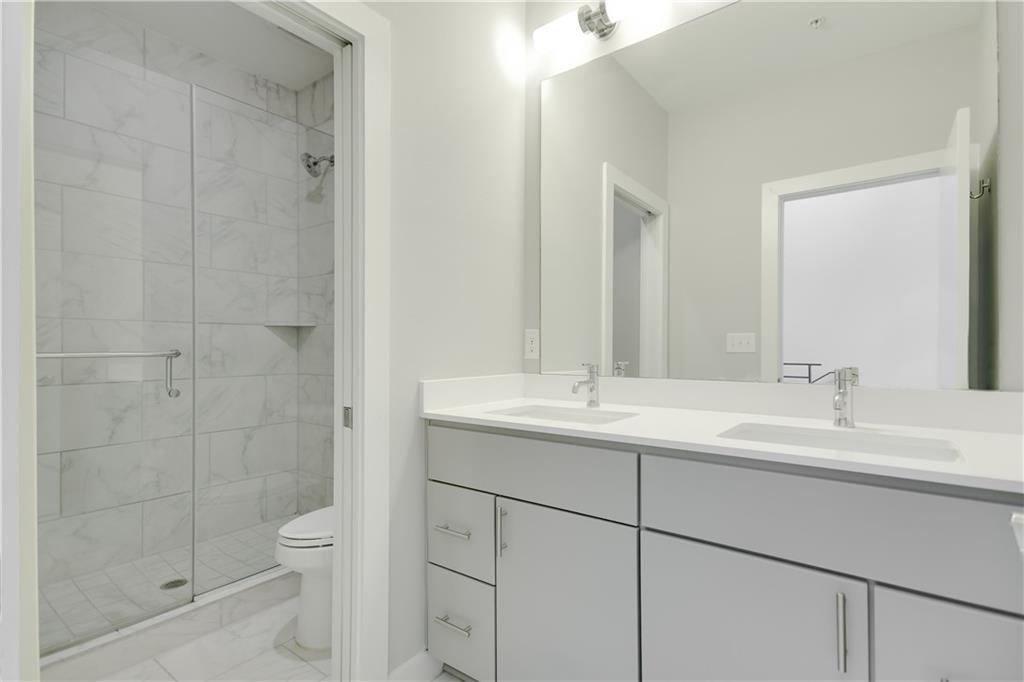 2002 East 7th Street, Unit 212 Austin, TX 78702 - Photo 10 of 23 a bathroom with a double vanity sink toilet and shower