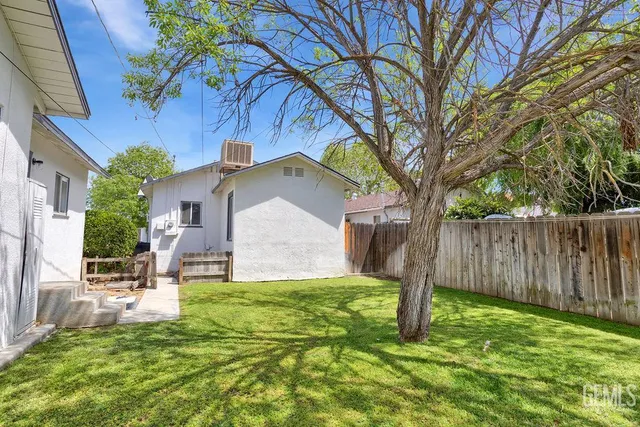a backyard of a house with table and chairs