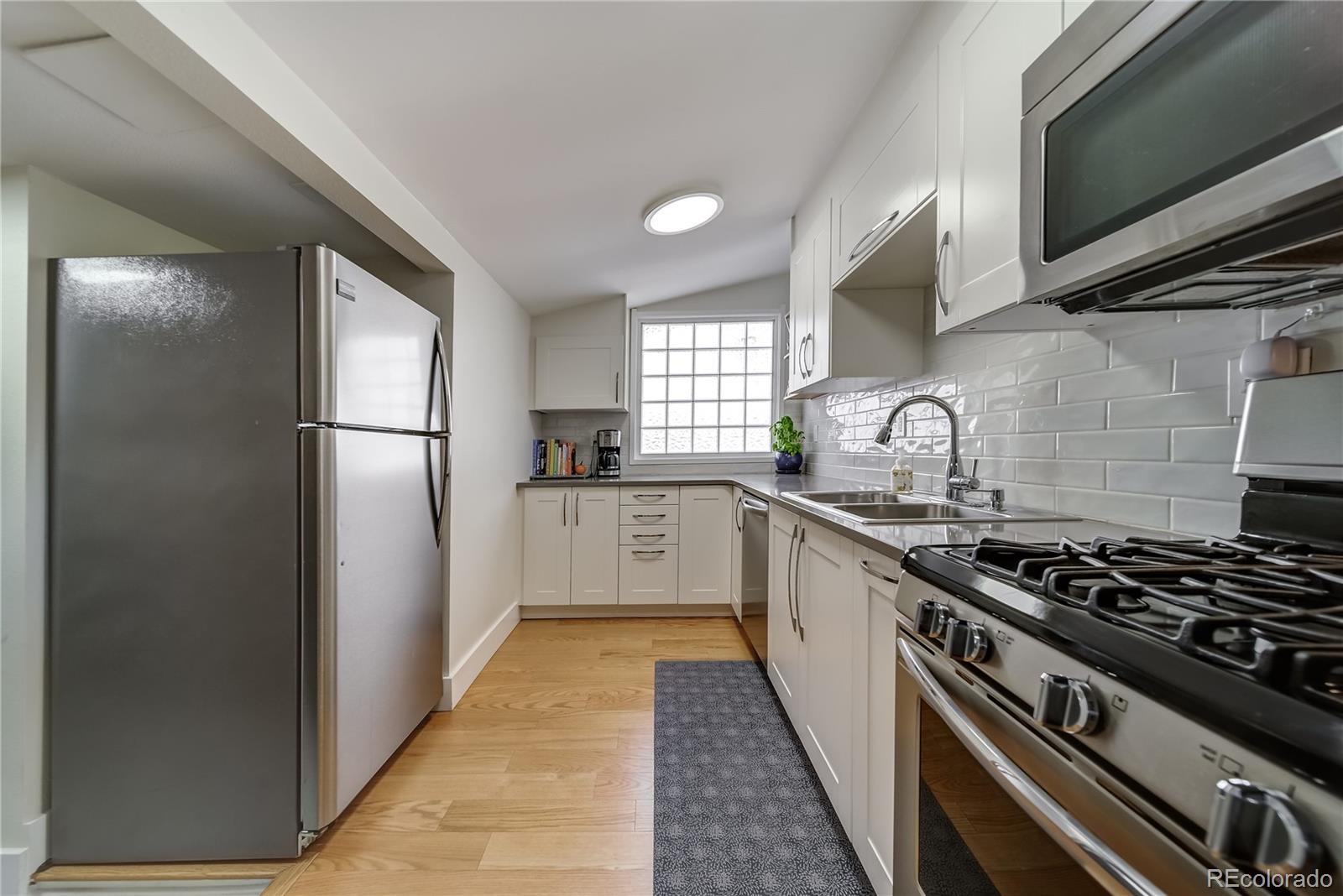 5129 Zuni Street Denver, CO 80221 - Photo 17 of 40 a kitchen with a stove and a refrigerator