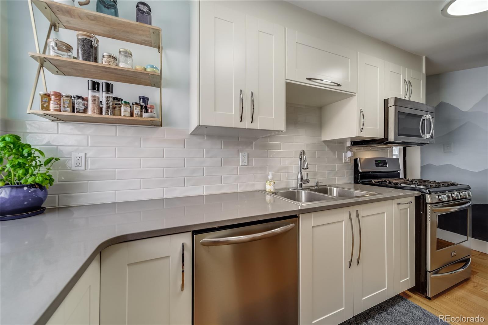 5129 Zuni Street Denver, CO 80221 - Photo 20 of 40 a kitchen with stainless steel appliances a sink a stove and cabinets