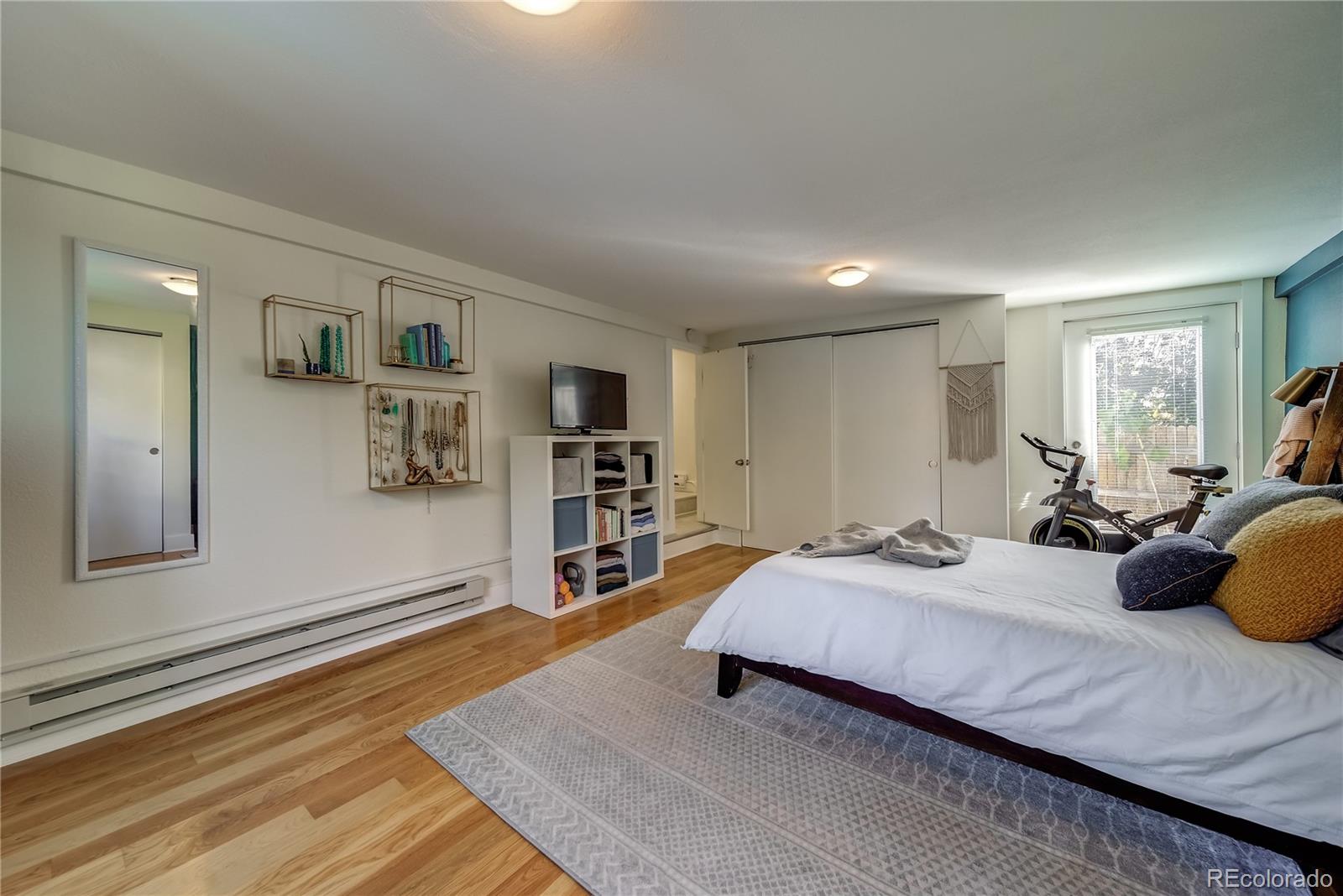 5129 Zuni Street Denver, CO 80221 - Photo 29 of 40 a spacious bedroom with a bed a dresser and book shelf