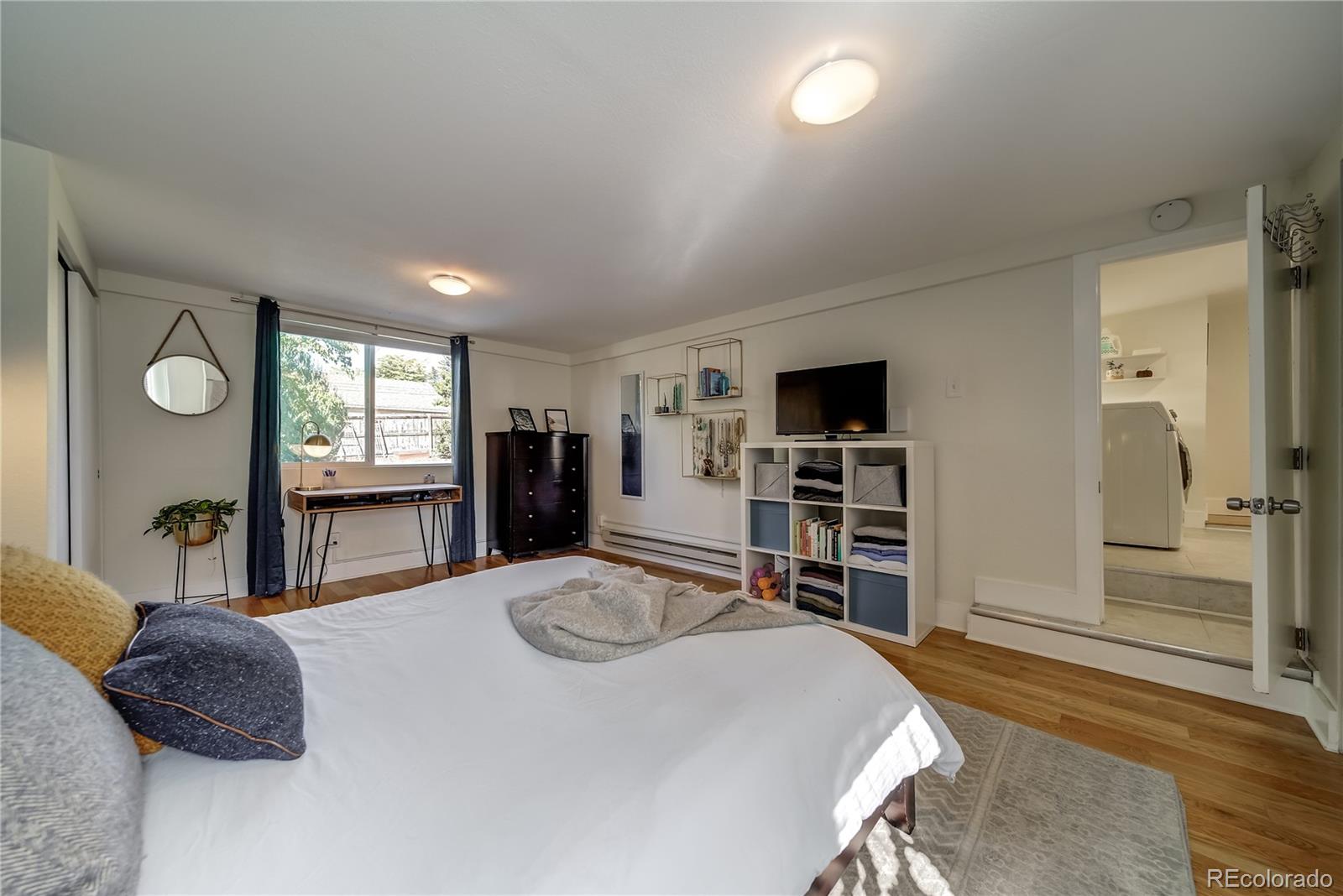 5129 Zuni Street Denver, CO 80221 - Photo 30 of 40 a bedroom with a large bed and a flat tv screen