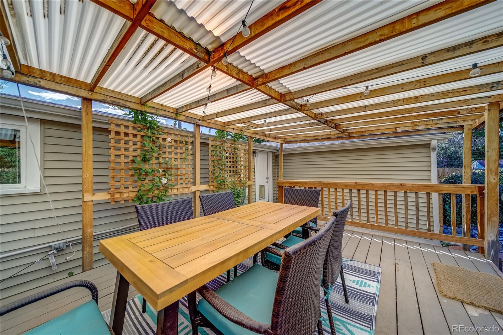 5129 Zuni Street Denver, CO 80221 - Photo 36 of 40 a view of a patio with table and chairs with wooden floor and fence