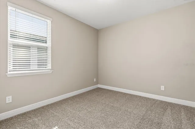an empty room with a windows and closet