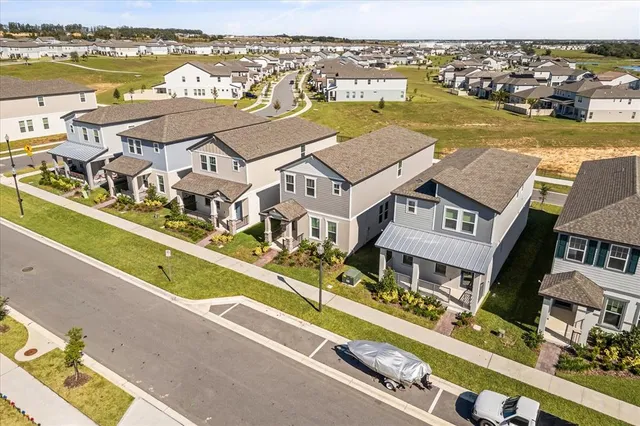 an aerial view of residential houses with outdoor space and ocean view
