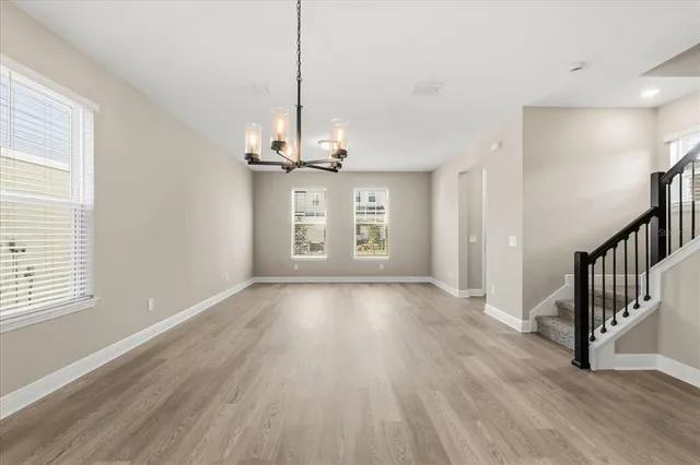 a view of empty room with wooden floor and window